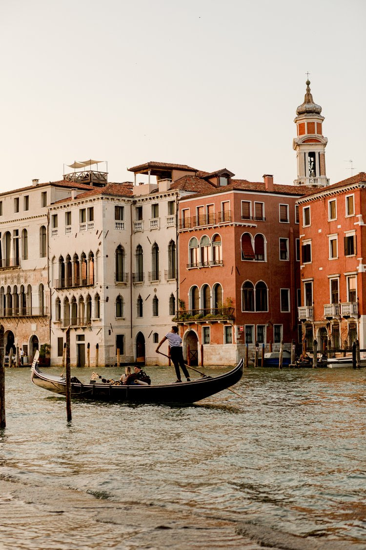 A gondola on a canal in Venice at golden hour.